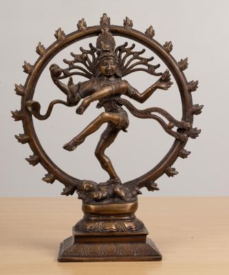 a bronze statue of the hindu god shiva on a wooden table