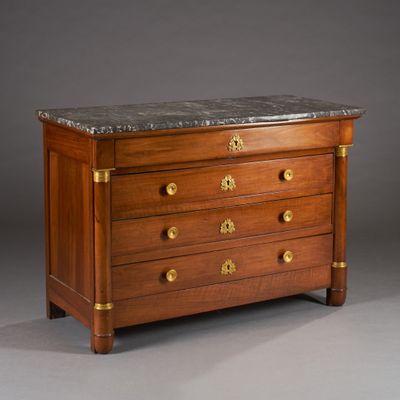 an antique chest of drawers with marble top and brass handles