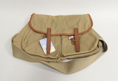 tan canvas messenger bag with tan leather handles and brown leather straps