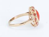 a close up of a gold ring with a red stone