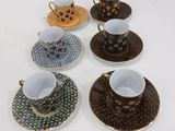 several coffee cups and saucers are lined up on a table