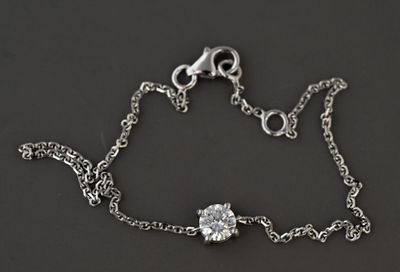 bracelet à chaîne en argent orné d'une pierre en cristal, sur fond noir