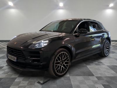 La Porsche Macan est garée sur un sol en carrelage à damier.