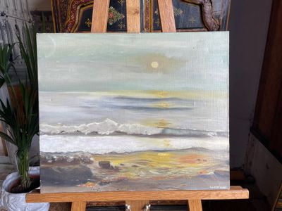 a painting on a easel with a plant in front of it