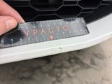 someone is measuring the front bumper of a car with a ruler
