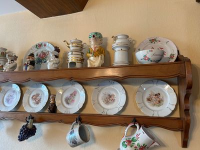 une étagère sur laquelle sont posées plusieurs assiettes et tasses