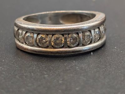 une image représentant une bague en argent posée sur une surface noire