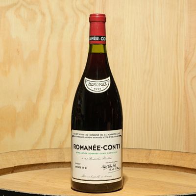 a bottle of wine sitting on top of a wooden barrel