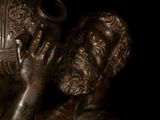 bronze statue of a man holding a vase in his hands