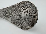 a silver spoon with a floral design on it