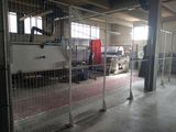 une grande clôture métallique devant un bâtiment dont la porte est rouge