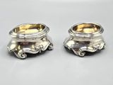 pair of silverplated salt and pepper shakers on a white surface