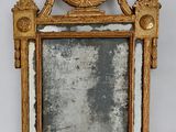 an antique mirror with a gold frame and a bird on top