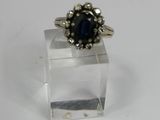 a close up of a ring on a clear stand on a white surface