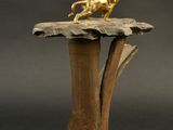 a gold statue of a lion on top of a wooden table
