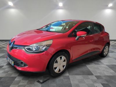 une voiture rouge est garée dans une pièce au sol en damier
