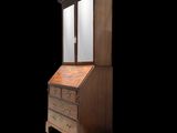 an old wooden bureau with a mirror on top of it