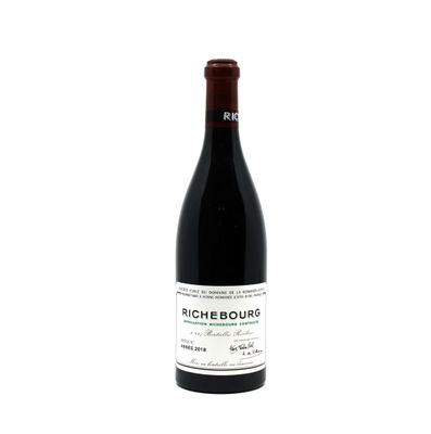 the bottle of wine is sitting on a white surface