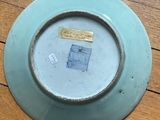 a plate with a picture on it sitting on a wooden table