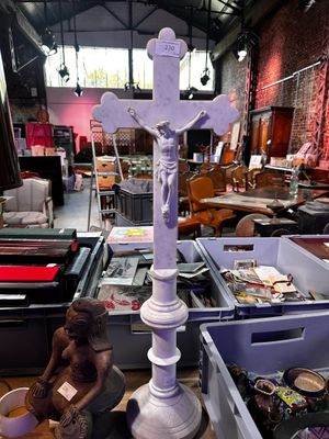 une statue de Jésus sur une croix dans une pièce remplie d'autres objets