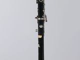 a close up of a black and silver clarinet on a clear stand