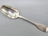 silver plated spoon with a long handle on a gray surface