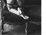 black and white photograph of a woman in lingerie sitting on a chair