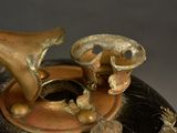 a black and gold vase with a horn on top of it