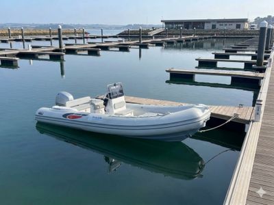 une image représentant un petit bateau amarré à un quai