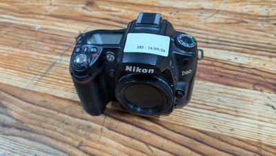 a camera sitting on a wooden table with a tag on it