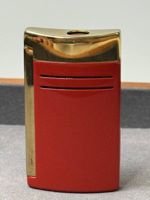 un briquet rouge posé sur une table près d'un mur blanc