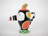 a black and white vase with a bird on top of it