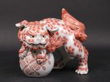 une figurine représentant un chien avec une balle dans la gueule