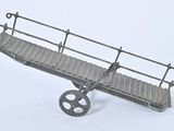 un petit train avec un pont dessus, posé sur une surface blanche