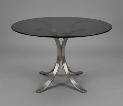 a round glass table with metal legs and a glass top