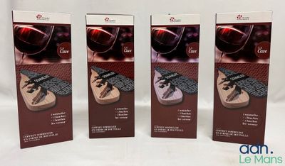 trois cartons de verres à vin et une bouteille de vin posés sur une table