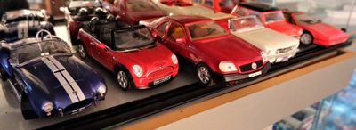 une vitrine sur laquelle sont exposées de nombreuses petites voitures