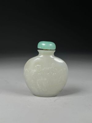 une fiole à tabac en verre blanc avec un couvercle vert