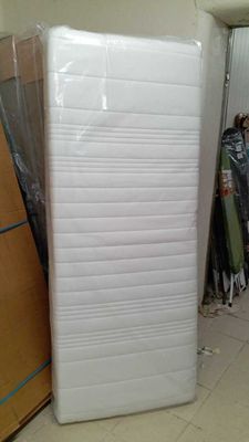 un matelas au milieu d'une pièce, près d'un mur
