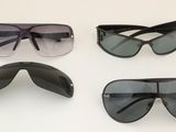 Trois paires de lunettes de soleil sont posées sur une surface blanche