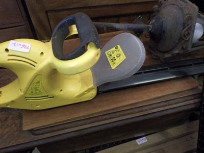 une tronçonneuse jaune posée sur une table en bois