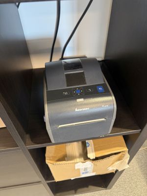 une imprimante posée sur une étagère
