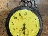 a yellow pocket watch sitting on a wooden table