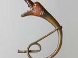 a metal sculpture of a horn on a stand