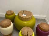 four different colored stools with wooden tops on the floor