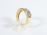 a gold and diamond ring on a clear stand