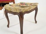 a small stool with a cushion on it next to a chair with a cushion on it