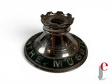 a silver candle holder on a white surface