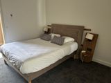 a bed with a white comforter and pillows in a bedroom