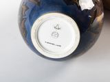 a blue vase with a gold decoration on it